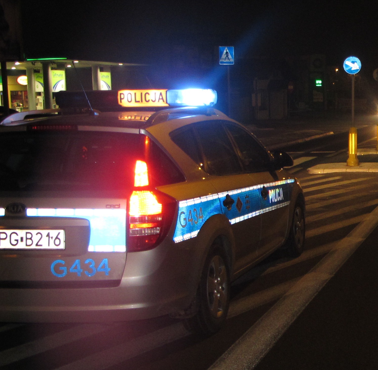 KPP Oświęcim radiowóz jadący ulicą na sygnałach w nocy
