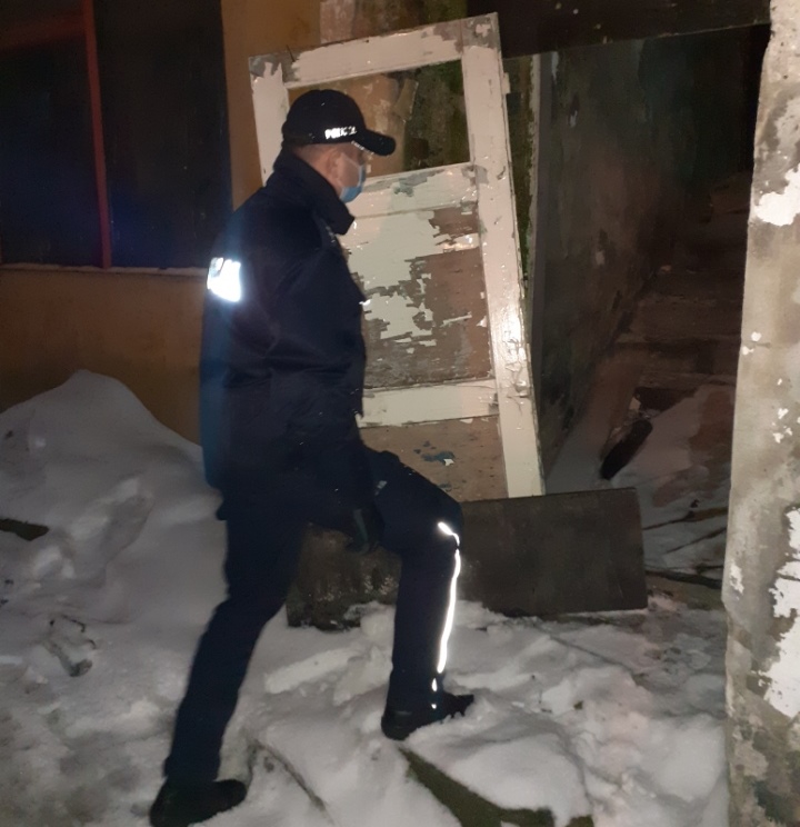 KPP Oświęcim Policjant w ramach akcji zima wchodzi do opuszczonego budynku