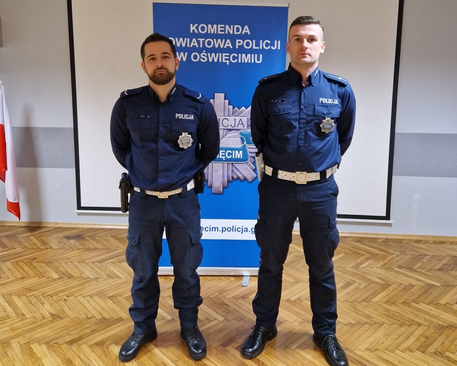 KPP Oświęcim. Policjanci Czajkowski i Pająk na tle rollap